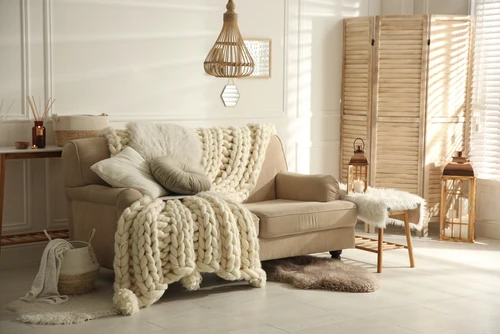 cozy living room with cushioned couch with blankets and cushions