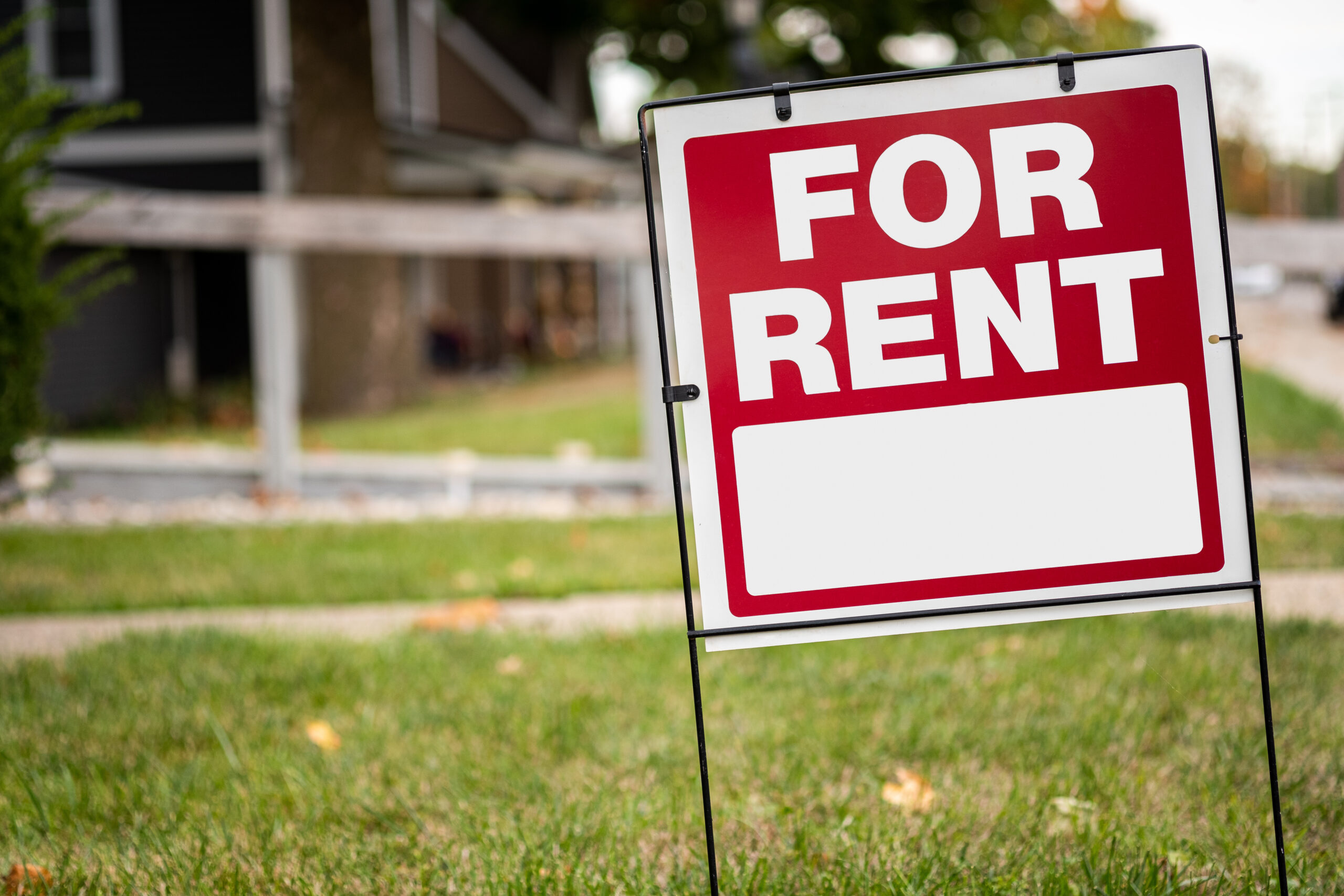 For rent sign in the yard in front of a house