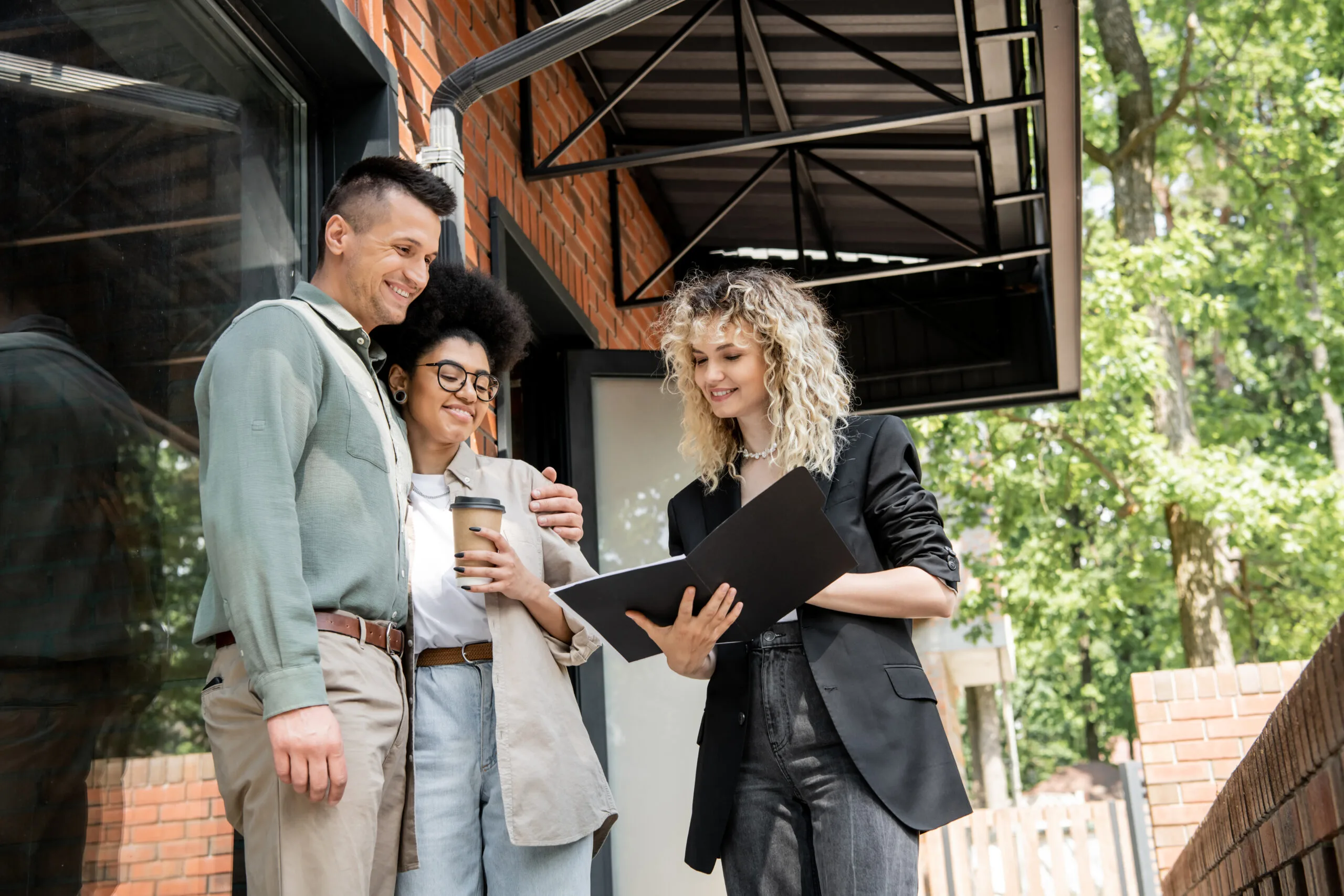 Smiling property manager showcasing what are landlords responsible for as she shows documents to a couple.