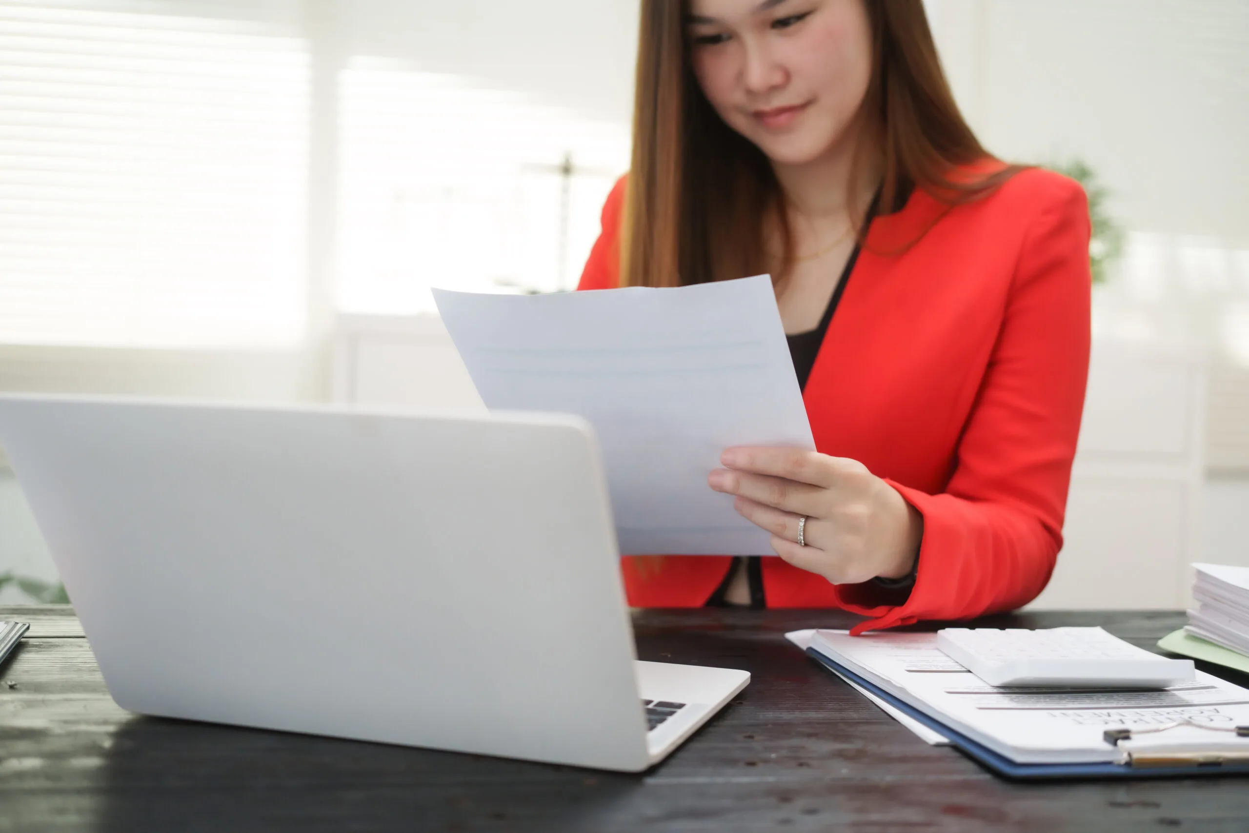 A smiling businesswoman reading over a paper