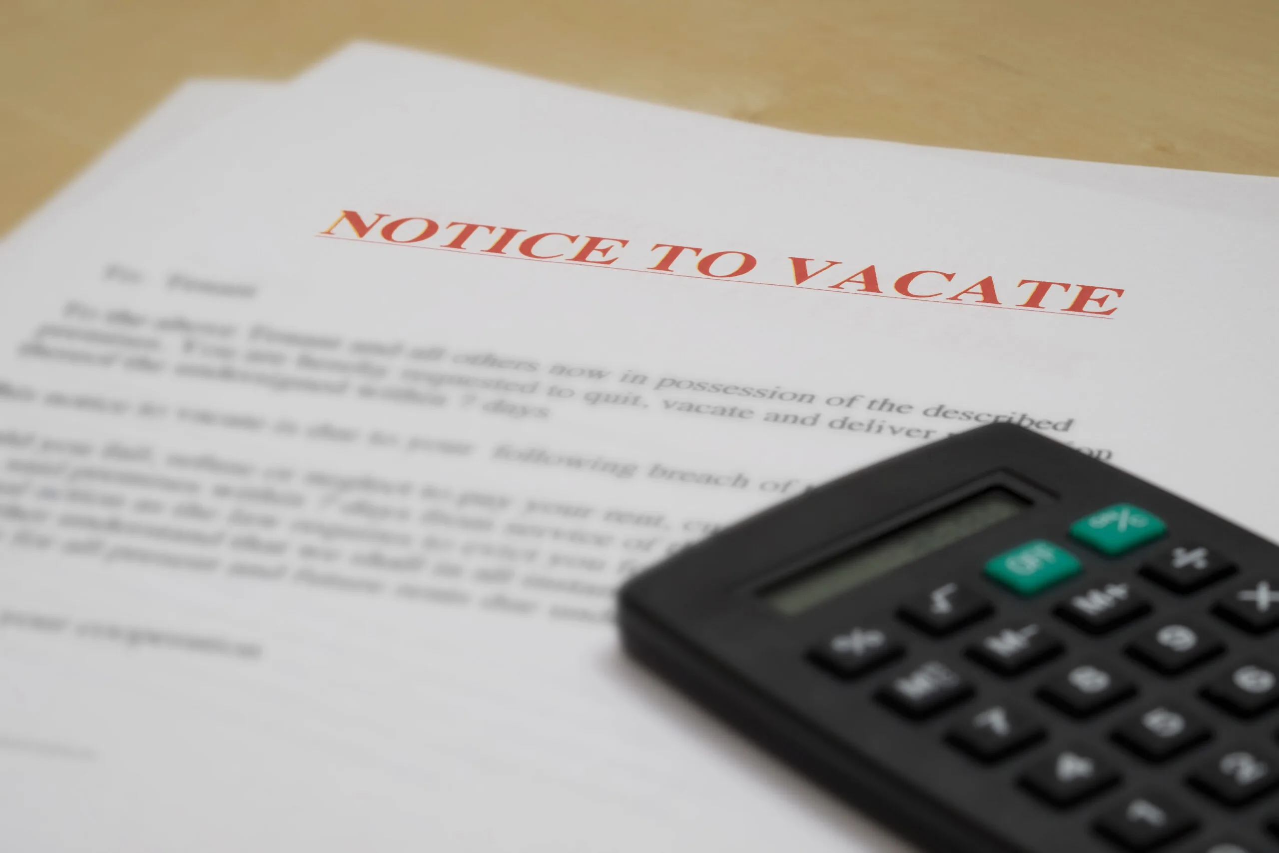 What is Considered a Wrongful Eviction in Texas, with a notice to vacate letter next to a calculator.