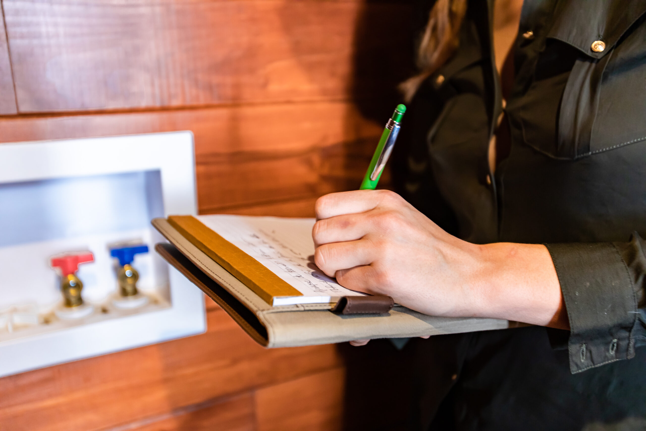 close up on woman's hands as she holding clipboard and takes notes during a apartment inspection in Texas. inspecting, modern eco energy efficient home