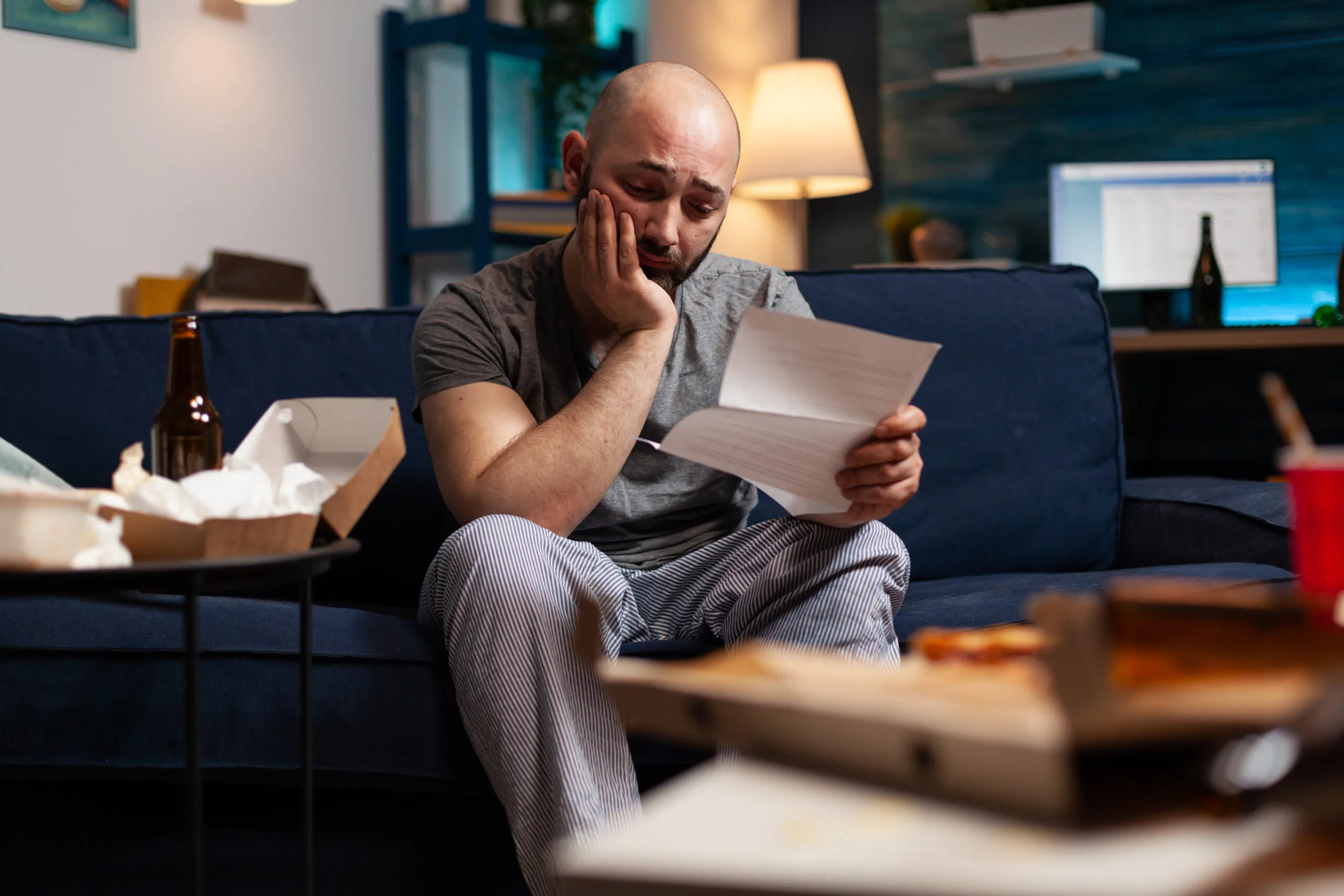 Desperate frustrated stressed young man reading eviction renter notice. 