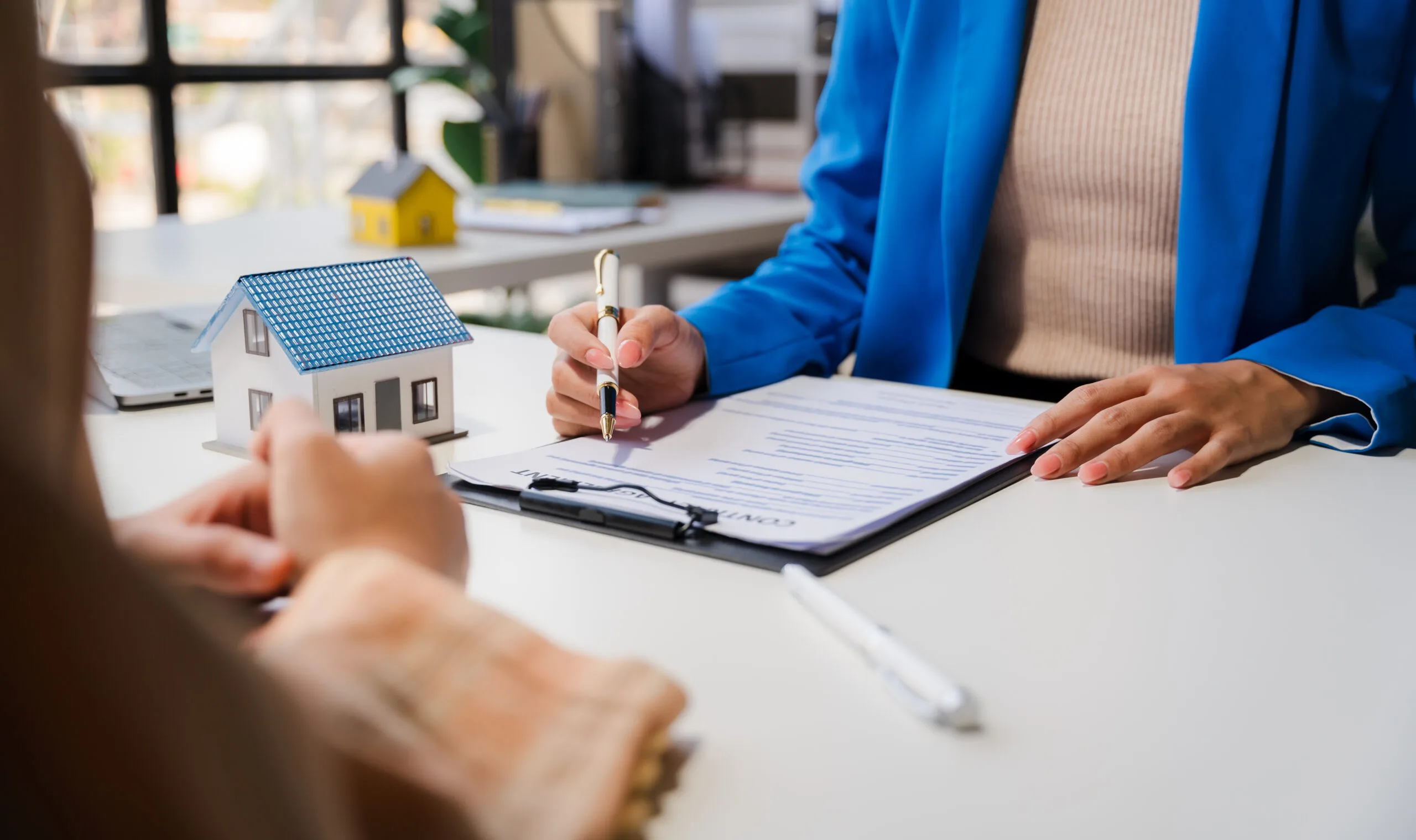 Real estate agent and client are negotiating prices before signing and discussing home purchases, insurance or moving home or renting property.