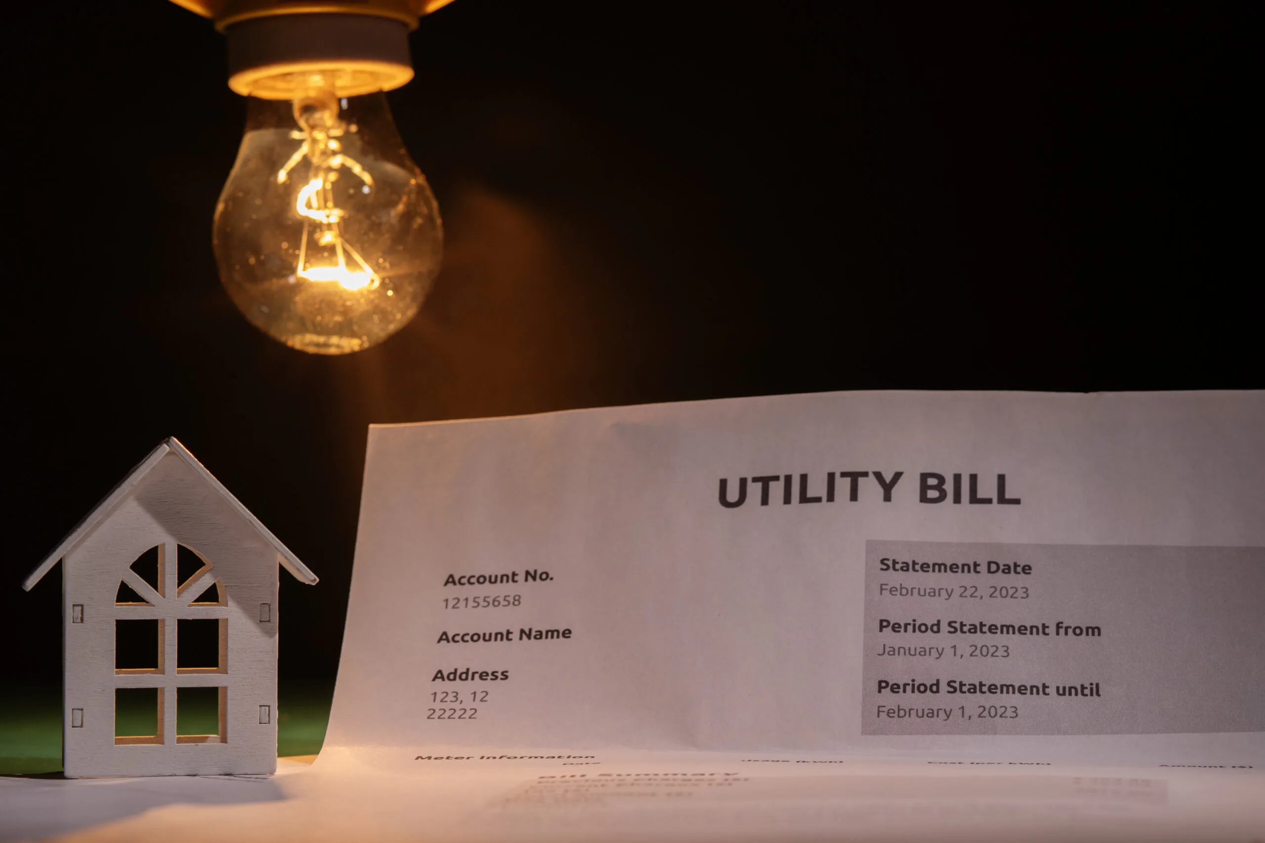 Utility bill and a house with a burning lightbulb