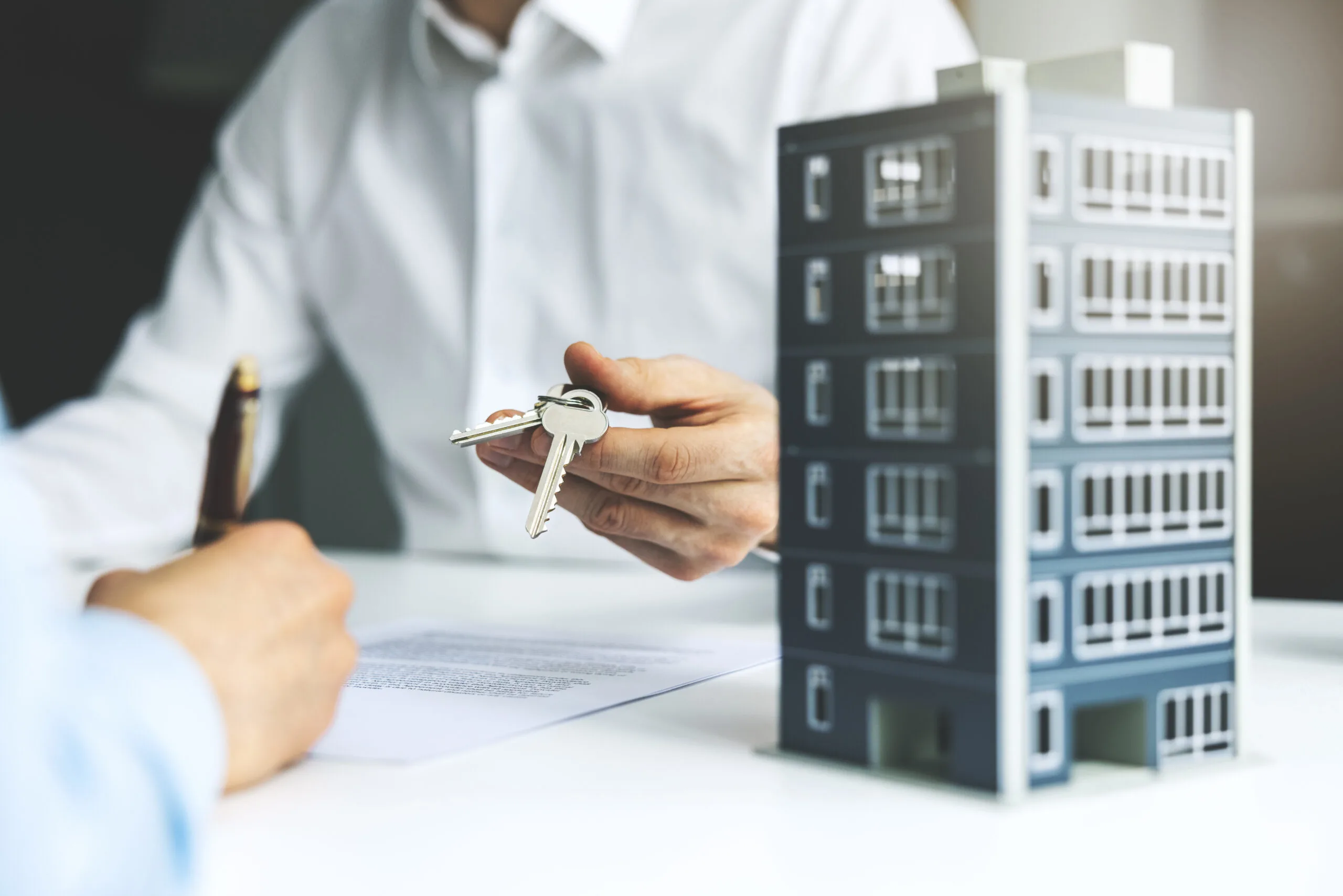 renter signing apartment lease and getting keys