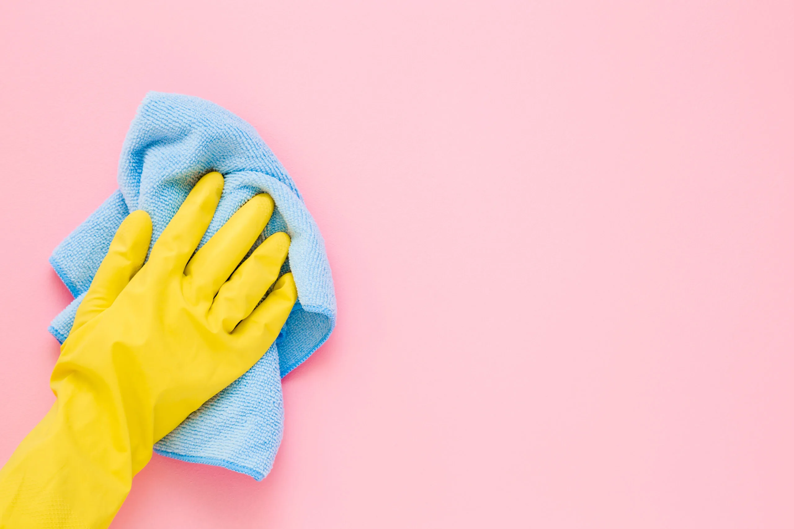 Employee hand in yellow rubber protective glove wiping