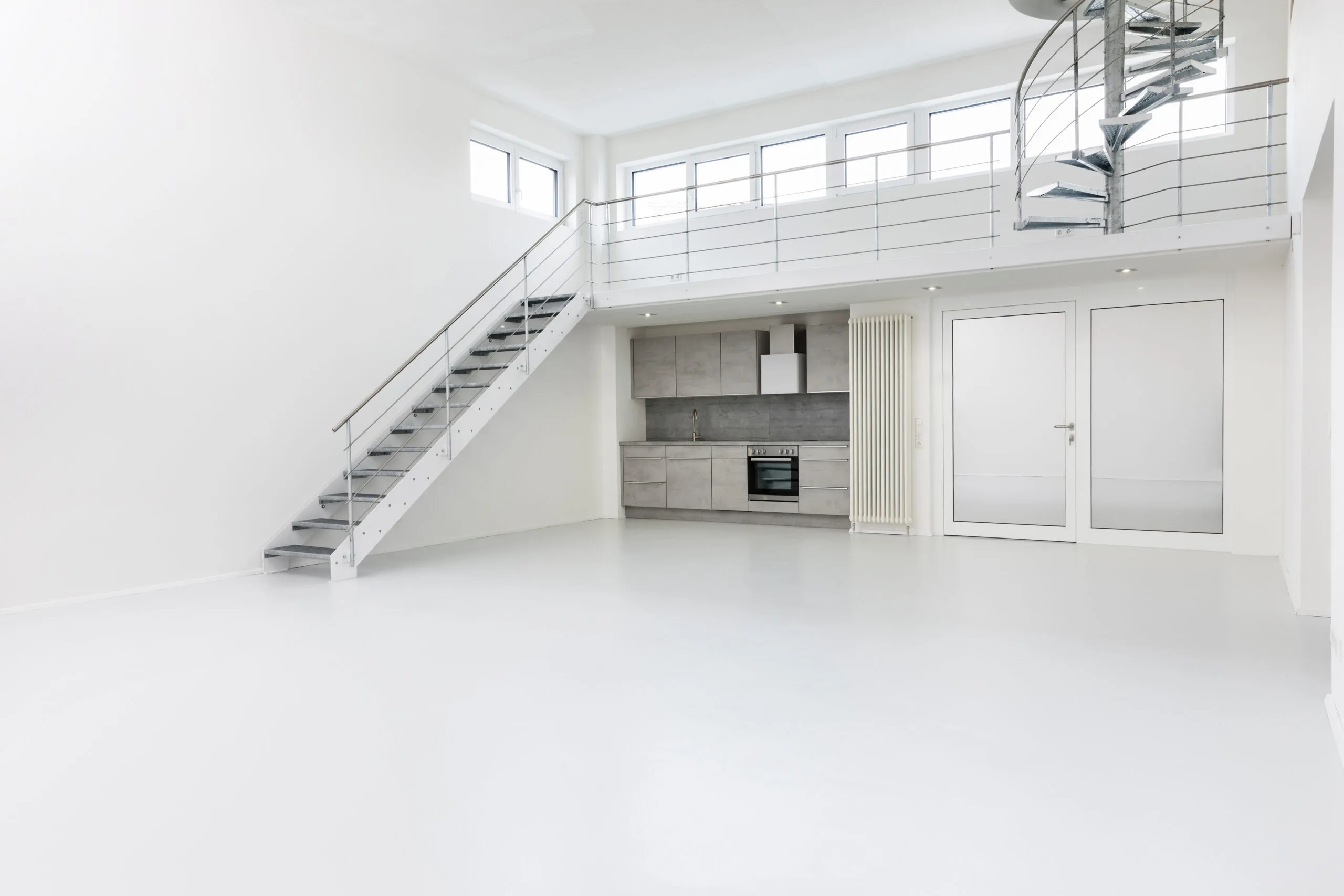 a white room with a raised bed and otherwise open space