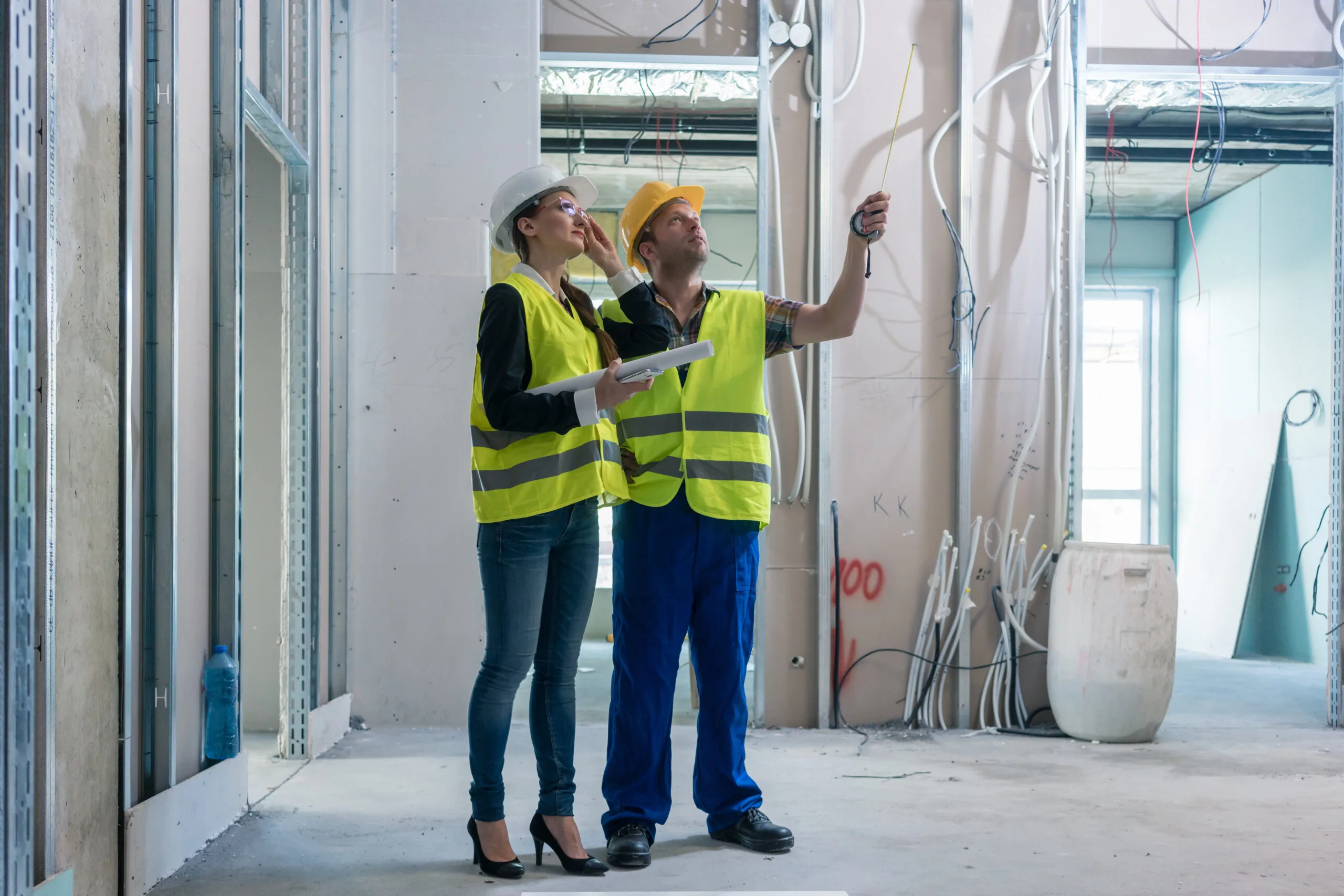 two construction workers huddling together and talking