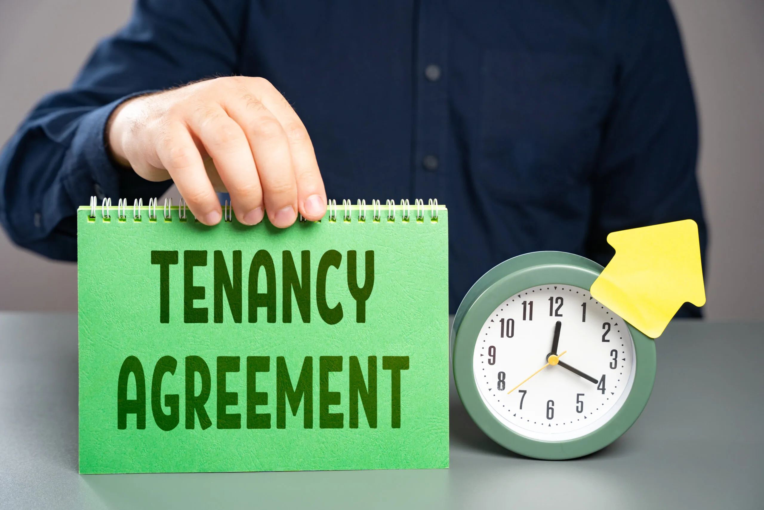 green paper saying "tenancy agreement" next to a green clock