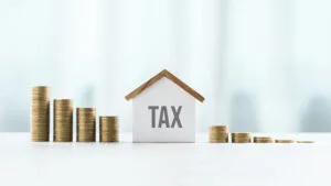 House model and stack of coins symbolizing the concept of real estate taxes, property tax rate in san antonio tx​