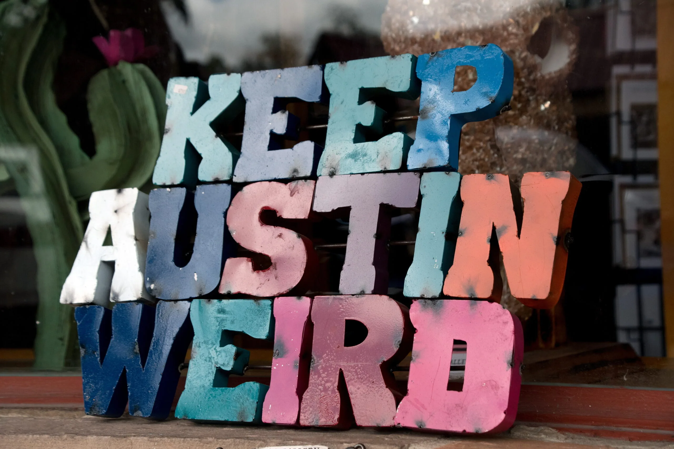 Colorful plate with word Austin in front of a shop window | Bay Management Group Texas