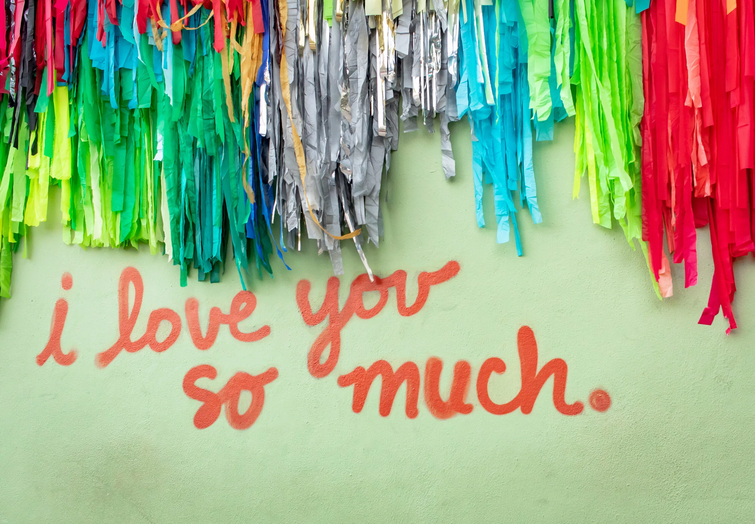 Famous green "I Love You So Much" mural in downtown Austin Texas with colorful confetti | Bay Management Group Texas
