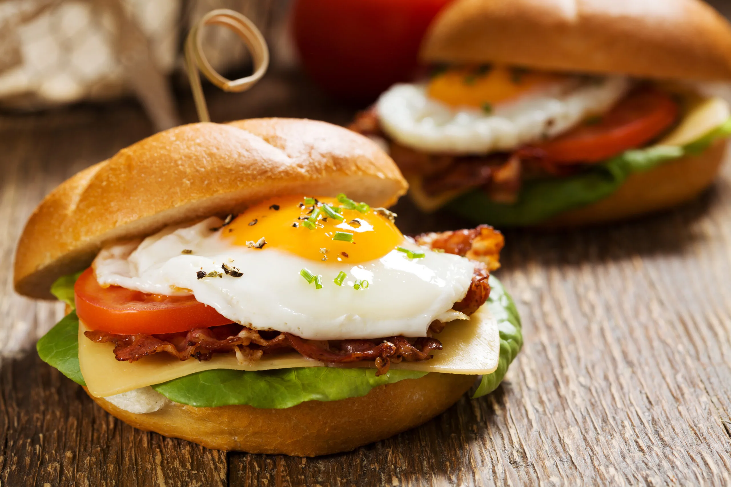 Sandwich with a fried egg, bacon, cheese and vegetables. | Bay Property Management Group Texas
