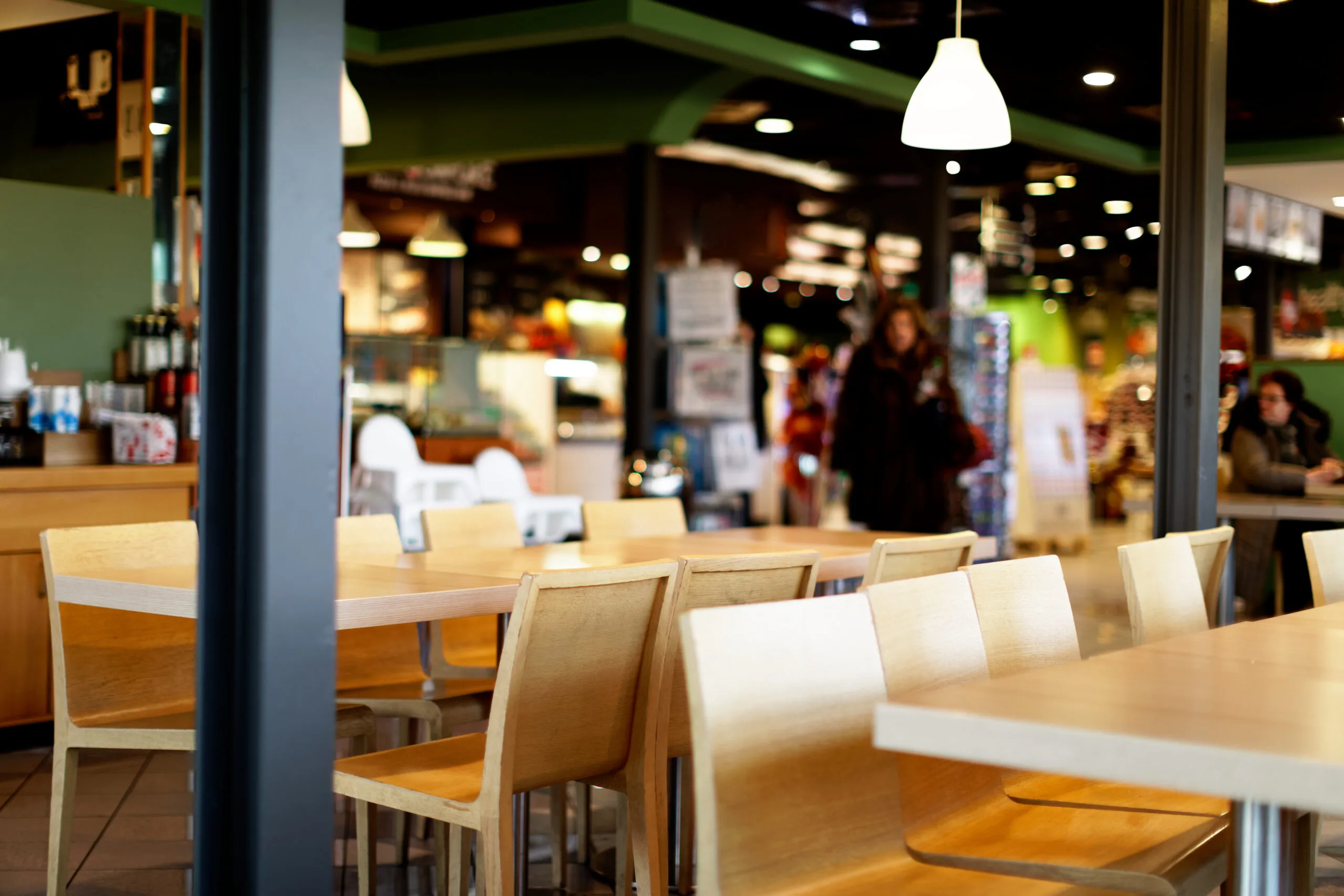 View of wooden tables and chairs in a motorway cafe self service restaurant | Bay Management Group Texas